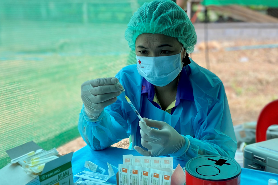 Thai Red Cross health worker prepares vaccine injection during vaccination campaign on 25 October in Tham Hin Temporary Shelter 
